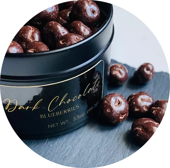 Dark chocolate blueberries in black tin container, circular cropped product image